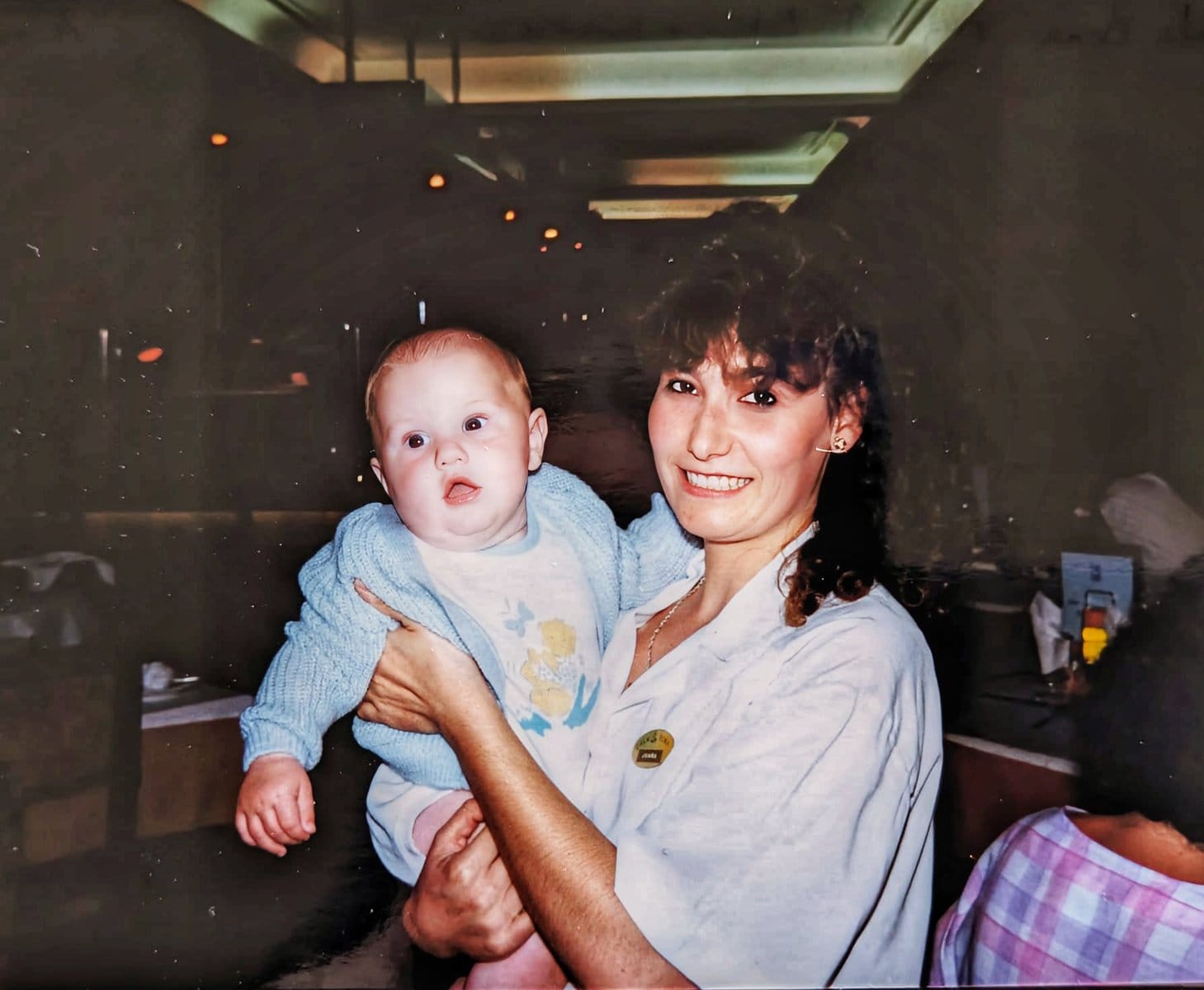 A baby being held by a Spanish waitress
