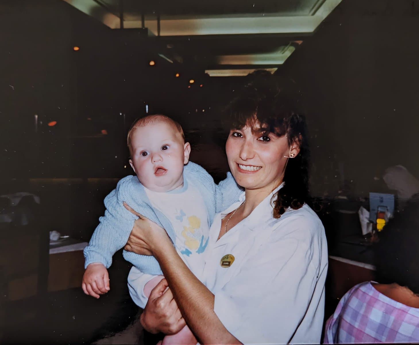 A photo of a baby being held by a Spanish waitress in the late 1980s.
