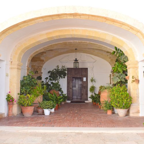 An alcove with potted plants and a door.