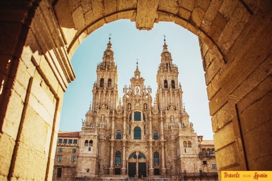 View of Santiago de Compostela Cathedral through an ancient stone doorway, a historic and iconic site among the best places to visit in Spain for first-time travelers.