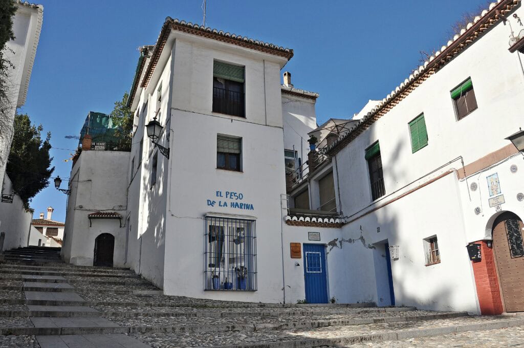 Traditional whitewashed building in the Albayzín district of Granada, Spain, with rustic charm and Moorish architectural details — a picturesque area to consider when choosing where to stay in Granada, Spain.