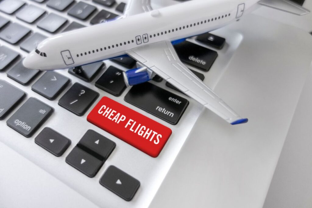 A laptop keyboard with a red key saying cheap flights to search for a cheap flight deal to Madrid.