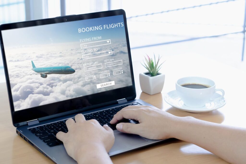 Close-up of person comparing flight prices on a laptop using a flight search engine