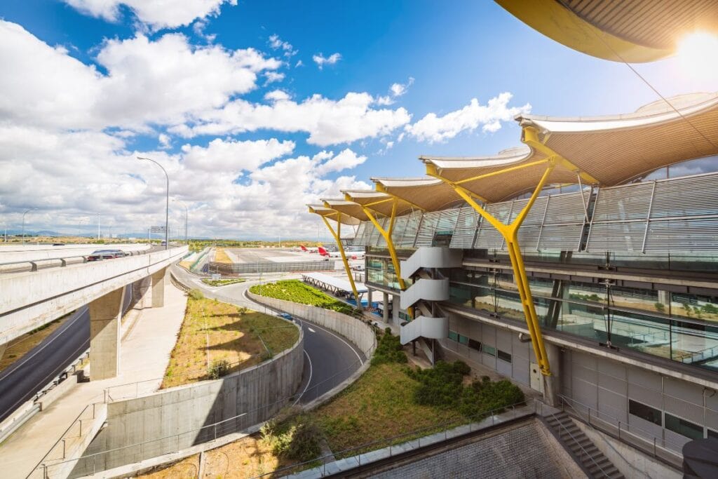 Exterior view of Madrid-Barajas Airport with clear signage and modern architecture.