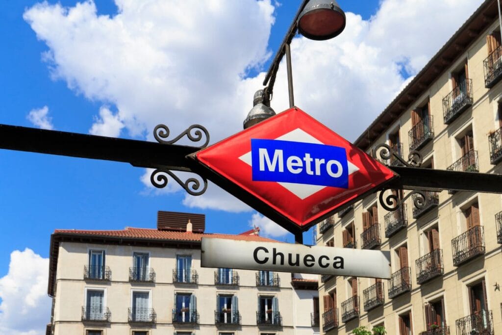 Madrid Metro sign and entrance with city streets in background
