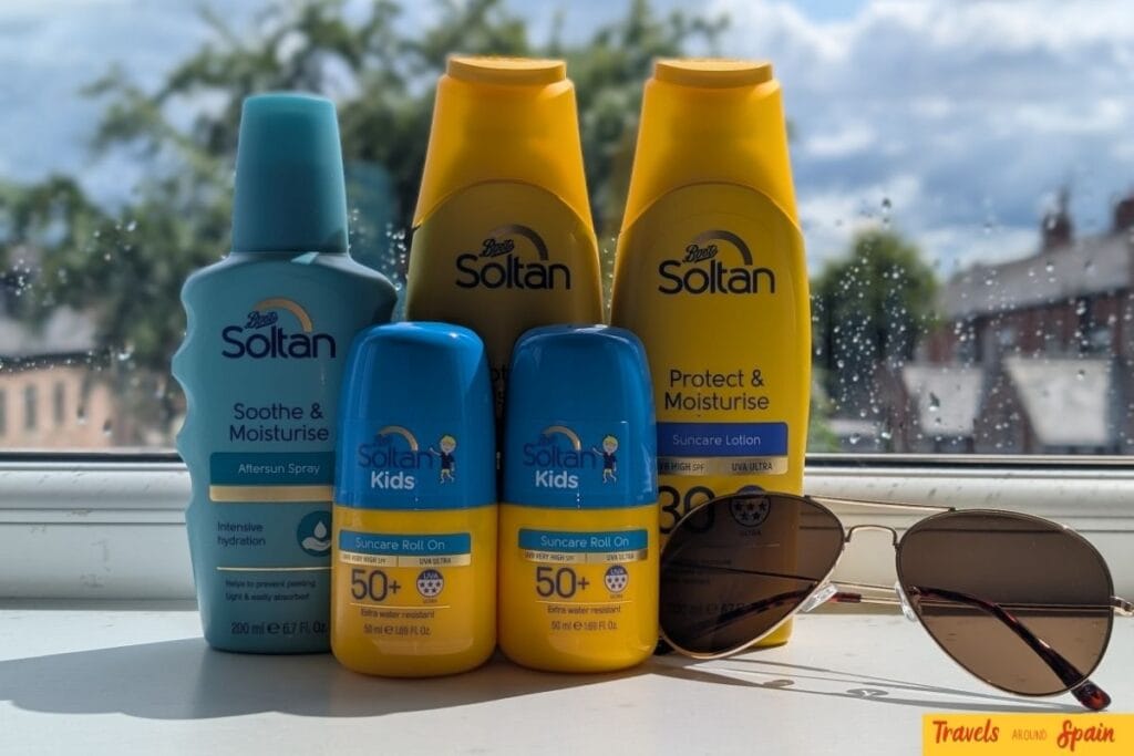 Sun protection essentials for what to pack for Gran Canaria in June - multiple SPF 50+ Soltan sunscreen bottles and polarized sunglasses on windowsill.