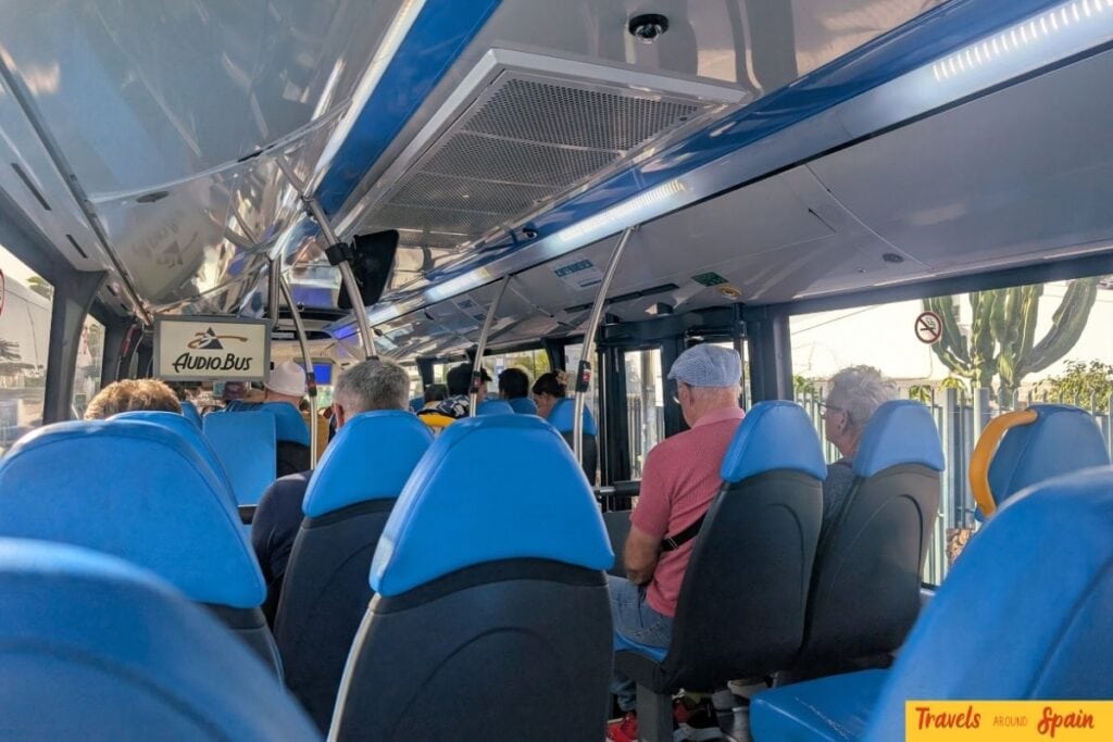 Inside Global bus from Maspalomas to Las Palmas Gran Canaria day trip passengers blue seats.