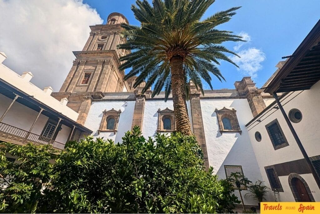 Las Palmas Cathedral courtyard in Gran Canaria showing historic architecture with palm trees and perfect year-round weather for cultural sightseeing.