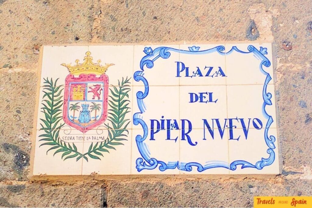 Traditional Spanish ceramic tiles in Gran Canaria showing Plaza del Pilar Nuevo with authentic Canarian cultural heritage and coat of arms.