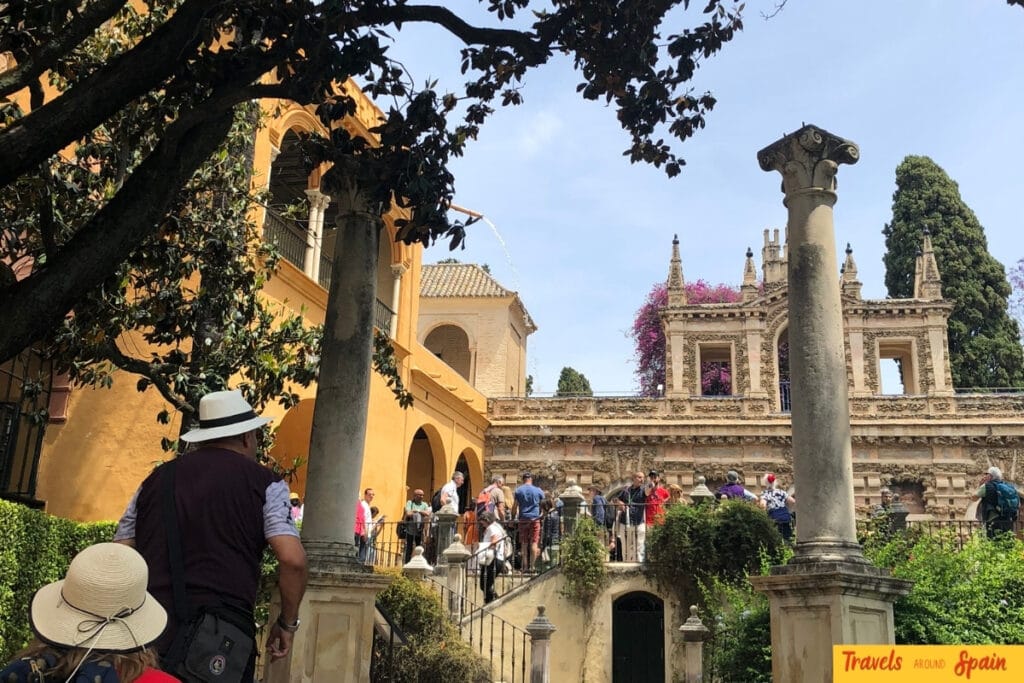 Tourists exploring Real Alcázar gardens under comfortable weather conditions with shade and pleasant temperatures