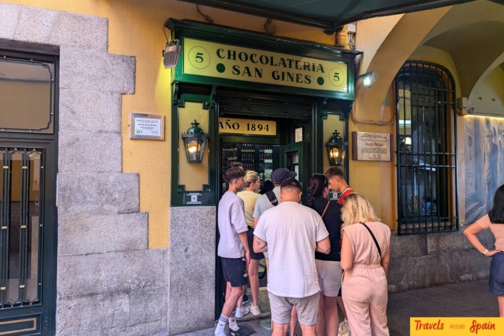 Queue outside famous Chocolatería San Ginés Madrid showing popularity