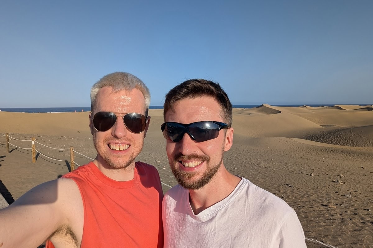 A couple taking a selfie in front of the dunes at Maspalomas at golde hour