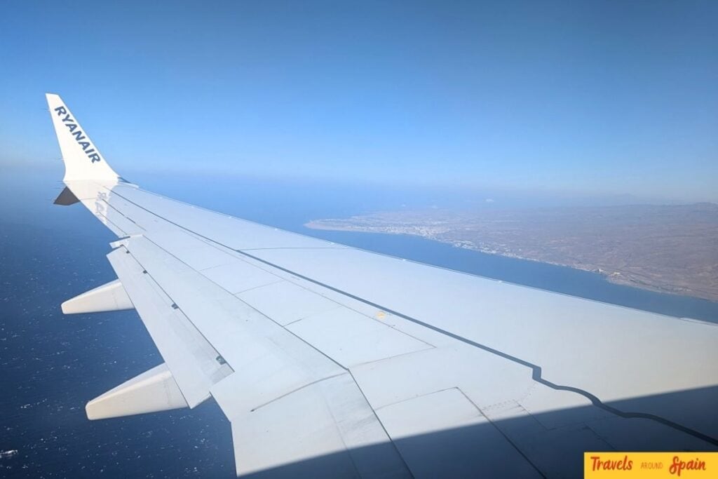 Airplane wing view or airport scene showing domestic flight options in Spain