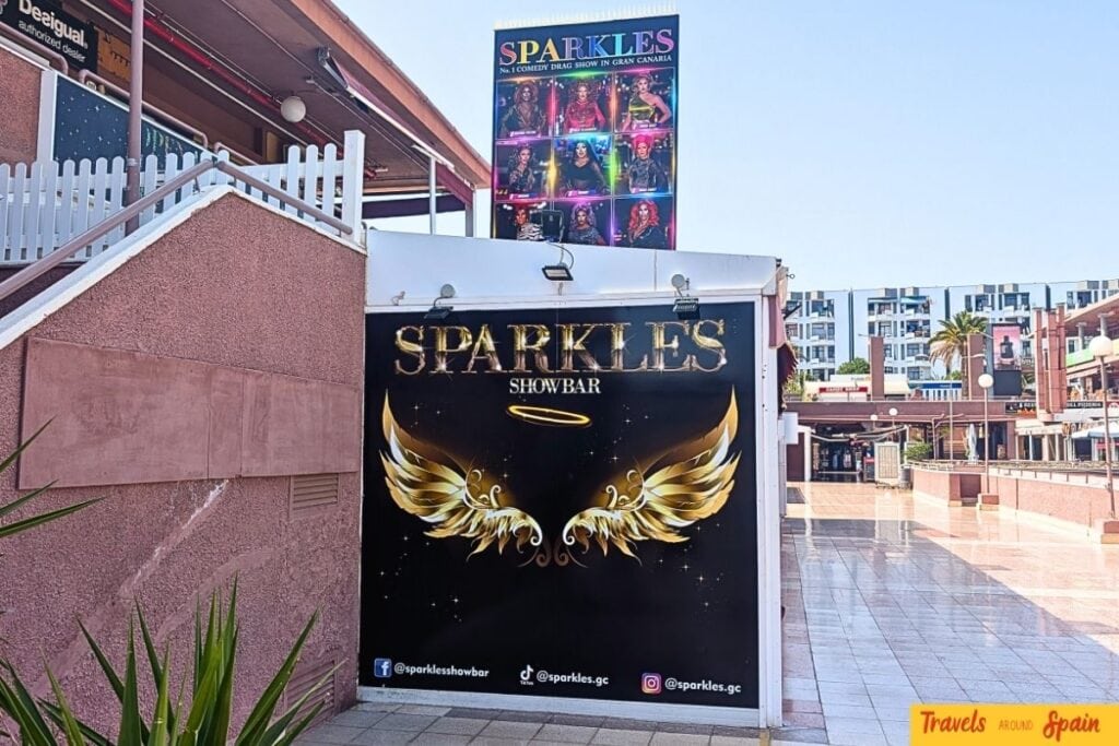 Sparkles Showbar entrance sign in Playa del Inglés showing golden wings logo and social media handles.
