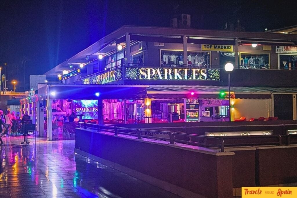Sparkles Bar Maspalomas exterior at night in Yumbo Shopping Centre, Playa del Inglés with neon signage.
