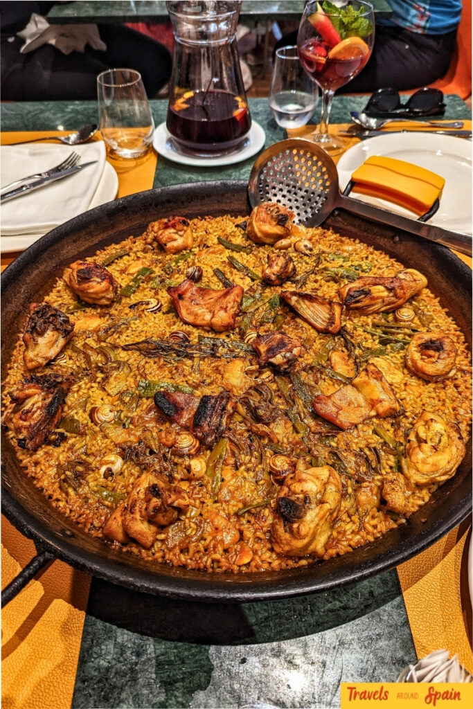Traditional seafood paella in a black pan with prawns, mussels and saffron rice served at a Valencia restaurant