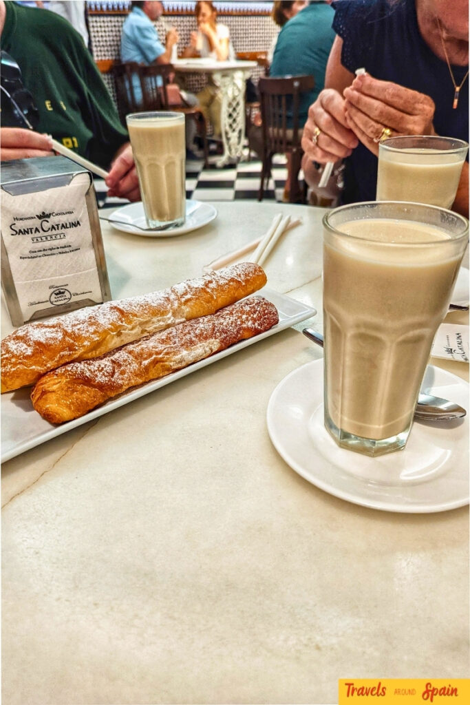 Traditional Valencia horchata drink served with fartons pastries on a white plate in a historic café