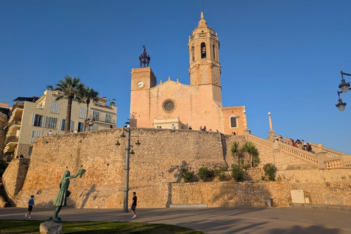 Sant Bartomeu church in Sitges during golden hour on clifftop promontory overlooking Mediterranean Sea