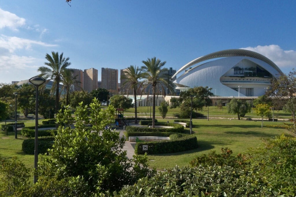 Modern art museum in Valencia, Spain with lush green park and clear blue sky.