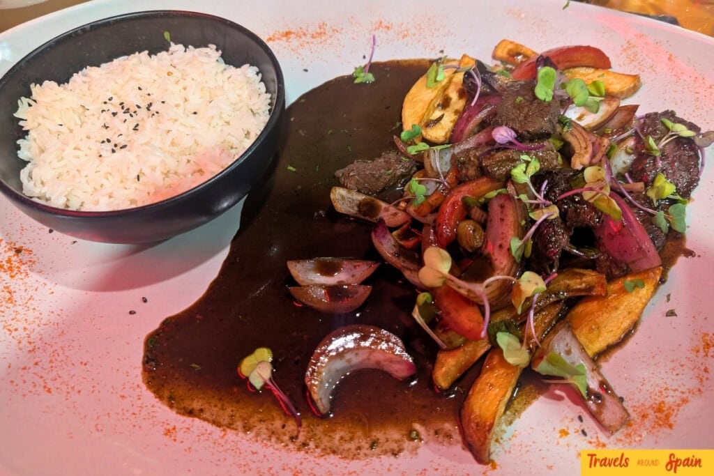 Traditional Peruvian lomo saltado with beef, onions and rice at Casa Perú in Sitges.