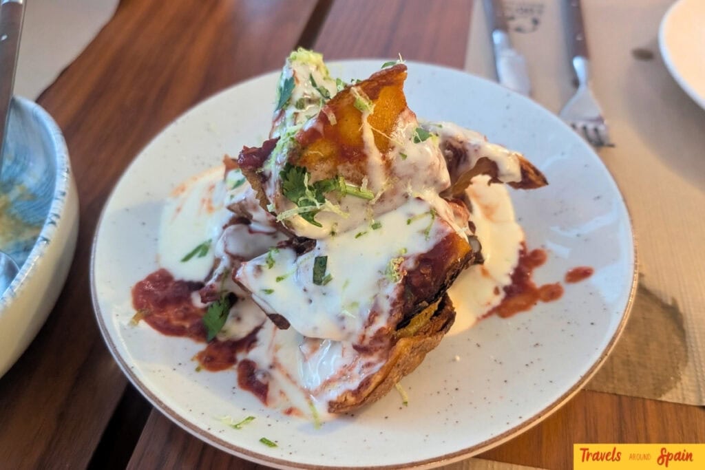 Patatas bravas topped with aioli and herbs at Nem in Sitges.