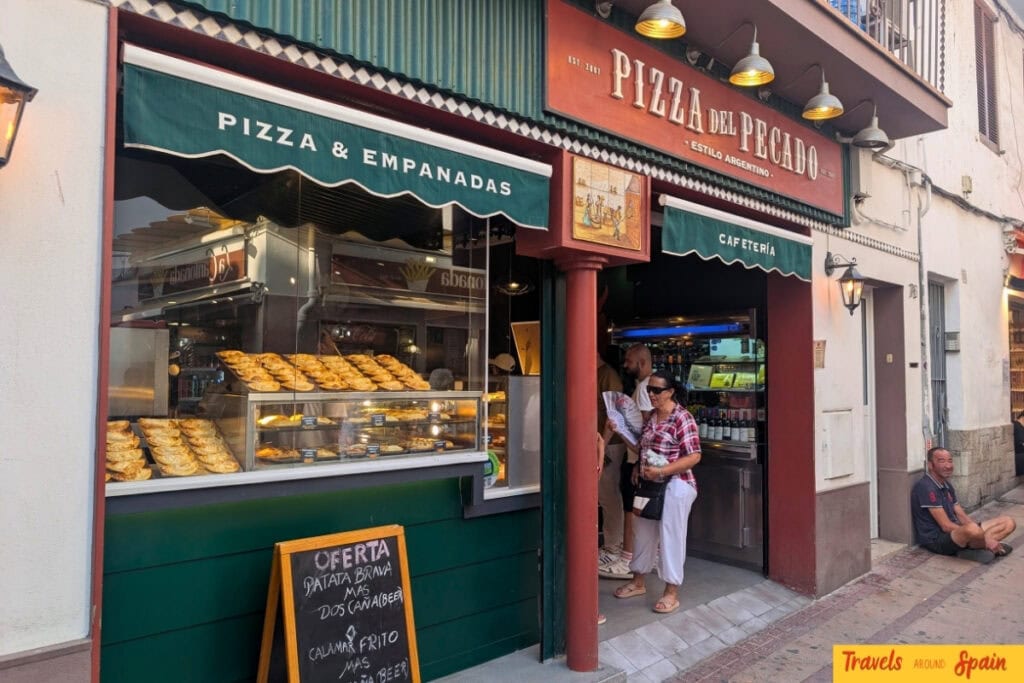 Entrance of Pizza del Pecat serving pizza and empanadas in Sitges.