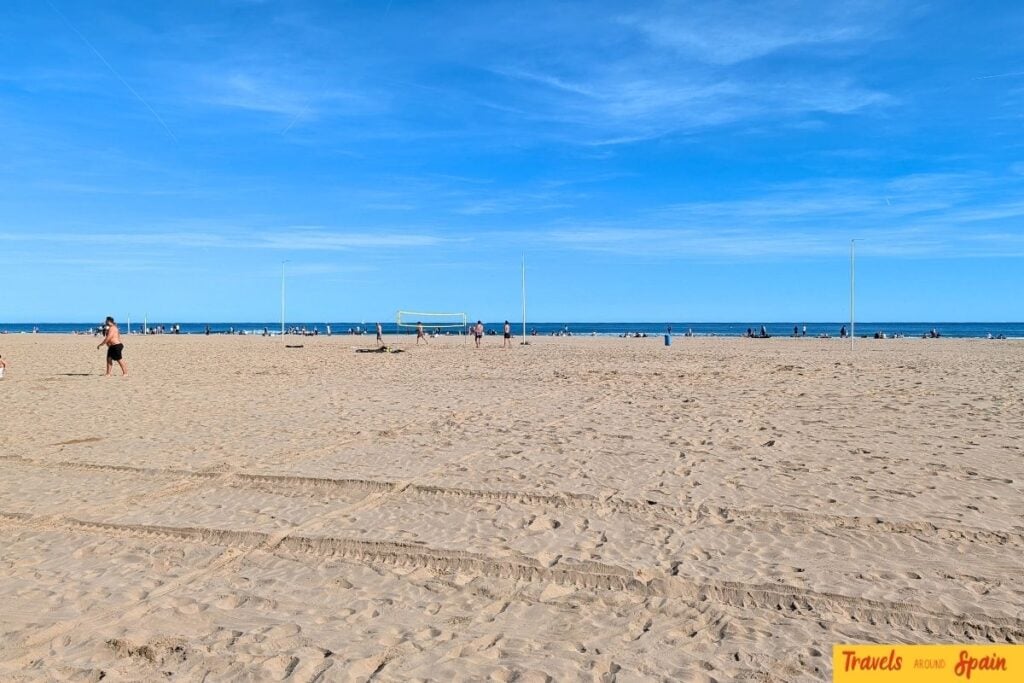 Quiet Malvarrosa Beach in Valencia with golden sand and blue November sky.