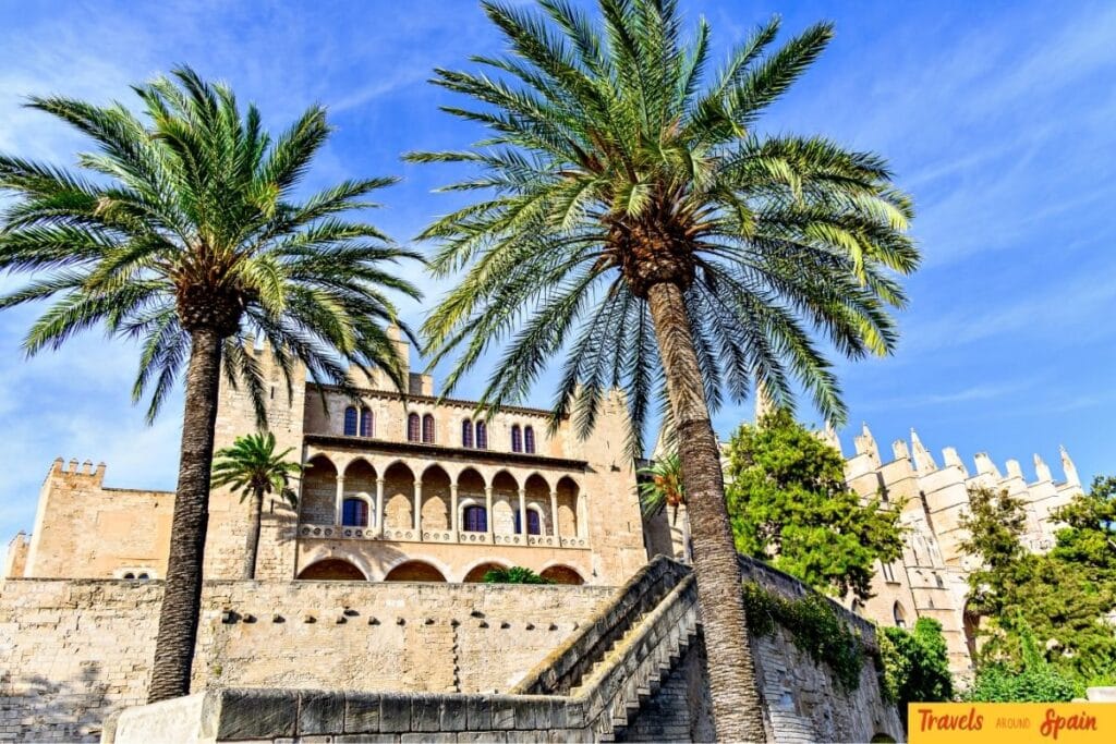 Palace of Almudaina with palm trees in Palma de Mallorca on a sunny June day