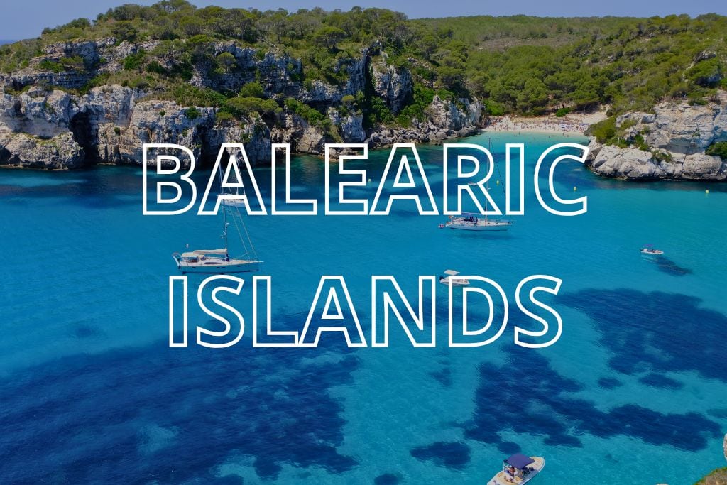 A turquoise bay in Menorca with the words Balearic Islands overlaid in white writing.