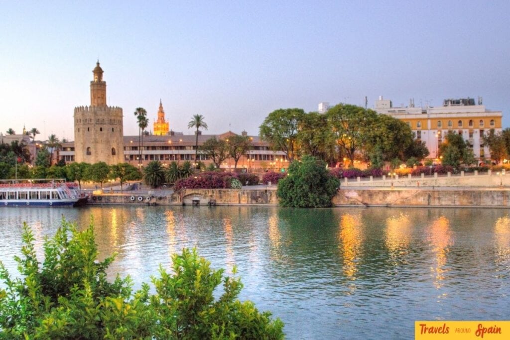 Torre del Oro illuminated beside the river in Seville
