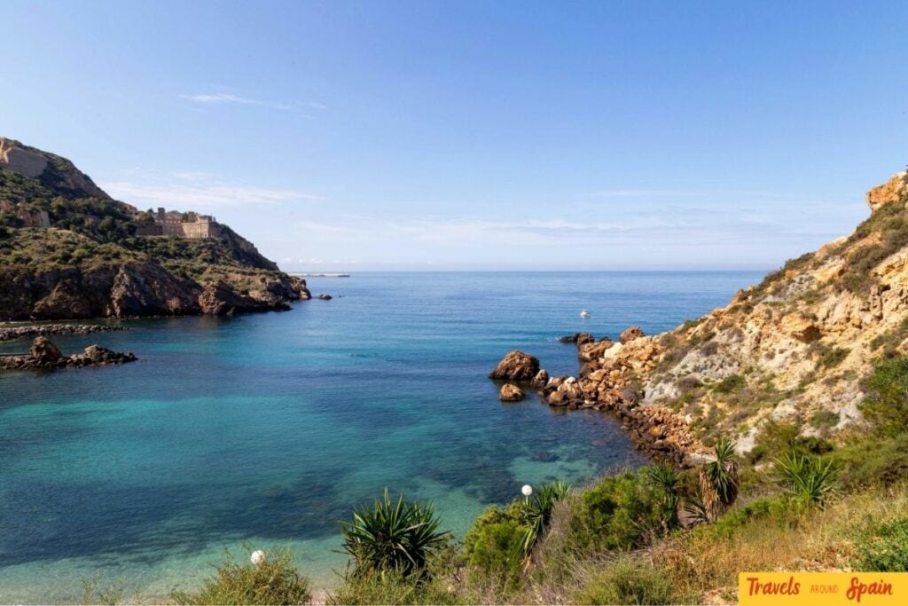 Clear blue water along the rocky coastline in Murcia during summer.
