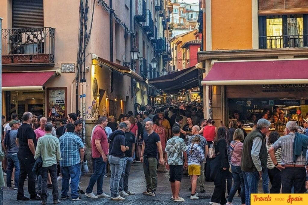 Crowded evening street in Spain with people dining and socialising.