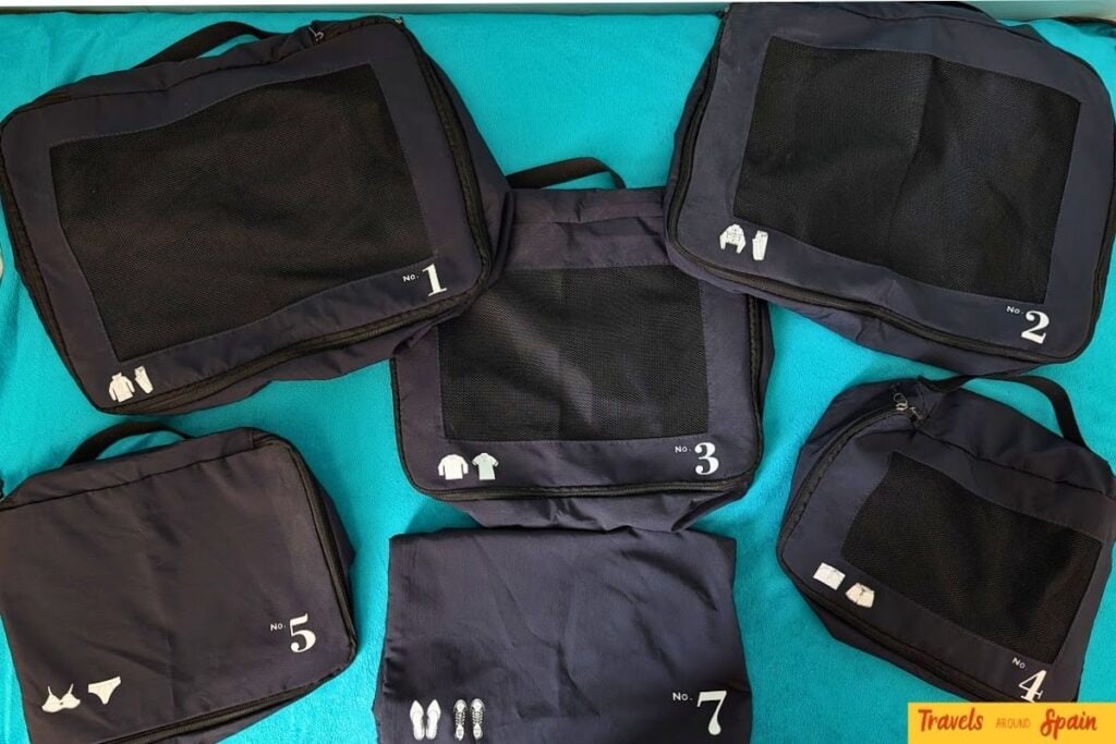 Packing cubes organised on a bed before a summer trip to Spain.