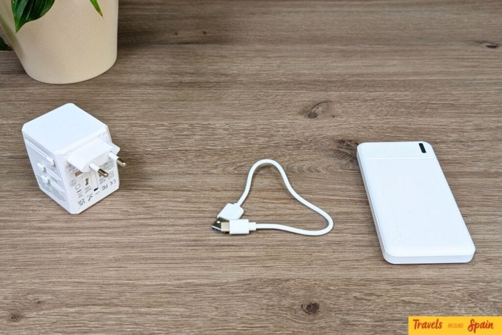 Travel adapter, charging cable, and power bank for Spain travel.