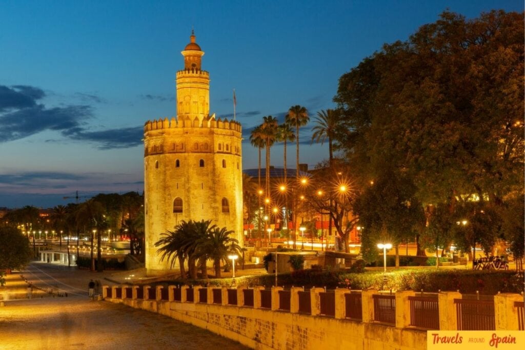 Torre del Oro illuminated beside the river in Seville