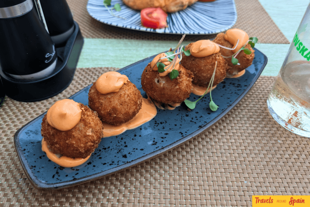 Five meat croquettes on a blue plate at Olive Tapas Bar in Maspalomas