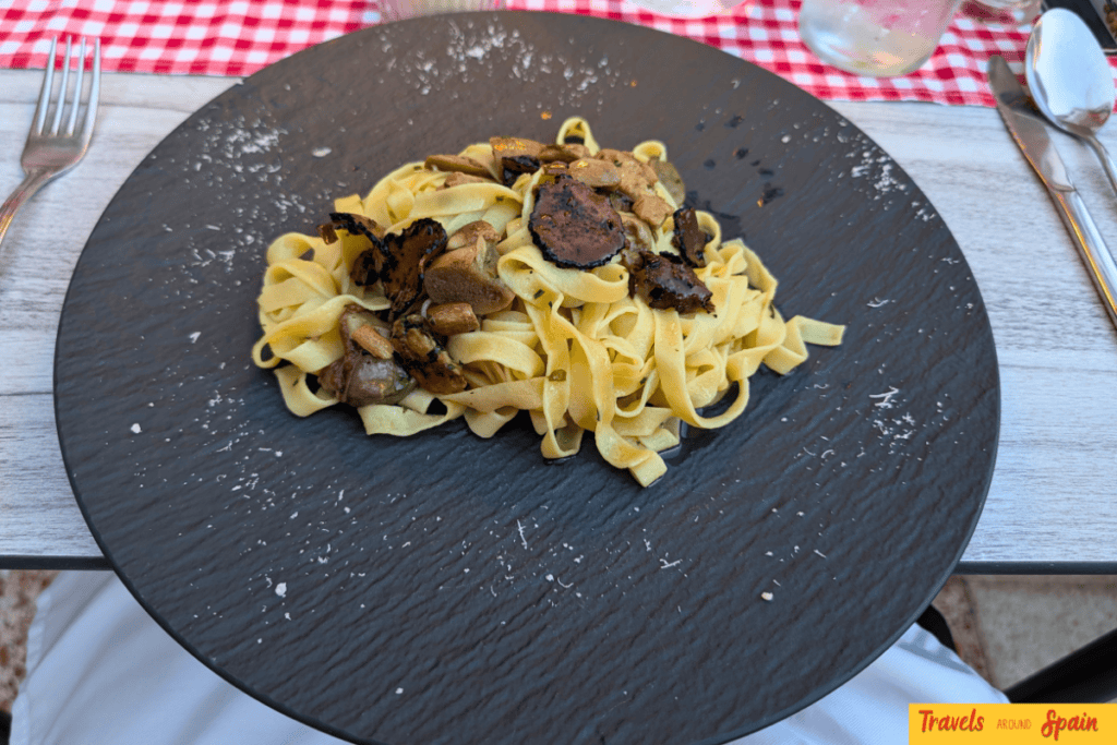 Truffle and mushroom pasta on a black bowl at Vi-Va La Italia in Maspalomas